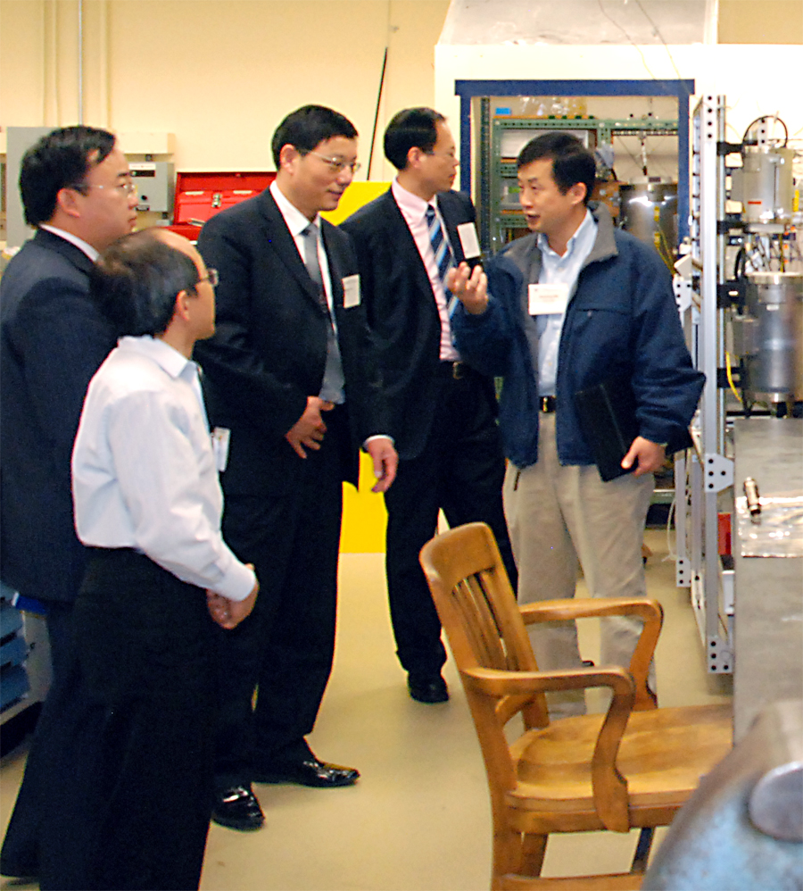 Xiaoliang Ma, senior research associate at the EMS Energy Institute, (right) discusses the equipment in an Institute lab with DUT visitors. 