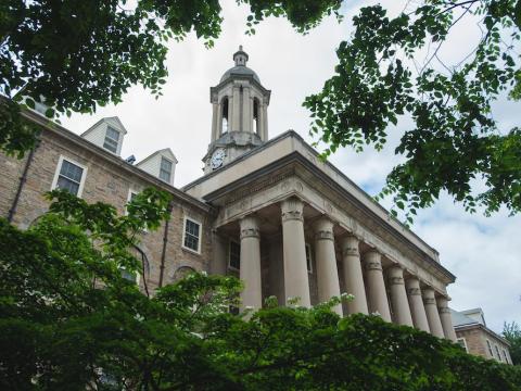 Picture of Old Main, a large stone building with large concrete pillars.