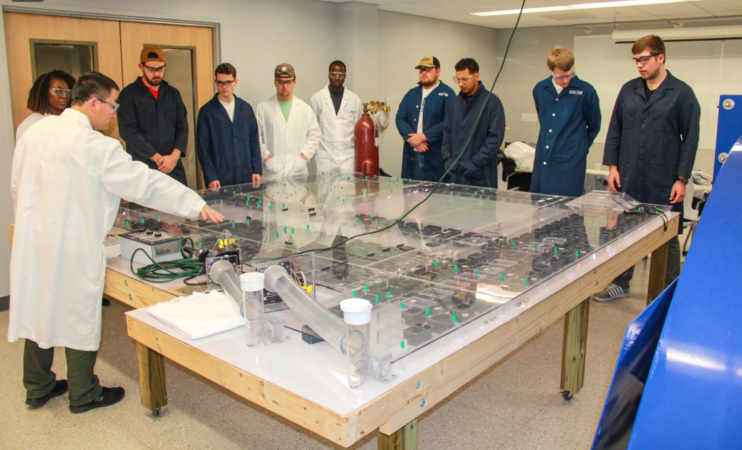 Penn State professor Shimin Liu demonstrates ventilation changes in the underground model to mining students.